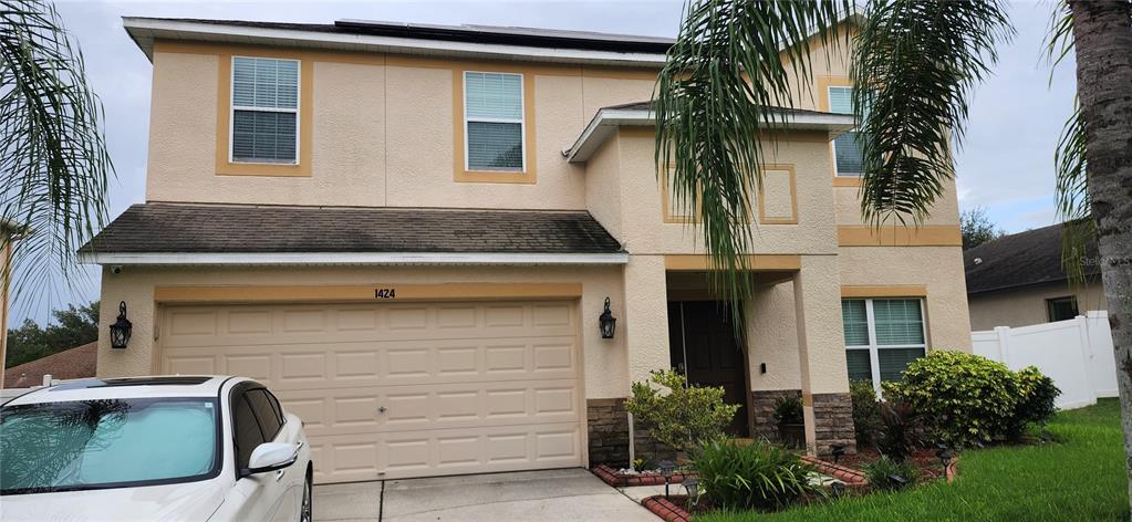 A two-story house with a tan stucco exterior, a two-car garage, and a front entrance — 1424 MAIN STREET, VALRICO, FL