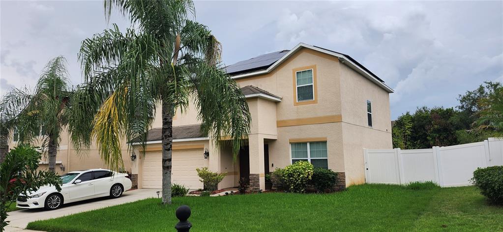 A two-story stucco house with a two-car garage and a white car in the driveway — 1424 MAIN STREET, VALRICO, FL