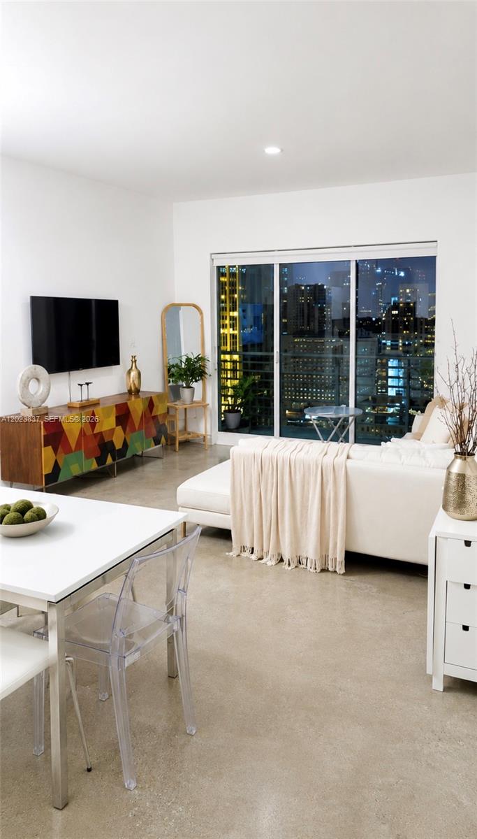 A modern living room features a colorful media console, white sofa, and floor-to-ceiling windows — 133 NE 2nd Ave # 2508, Miami FL 33132, MIAMI, FL