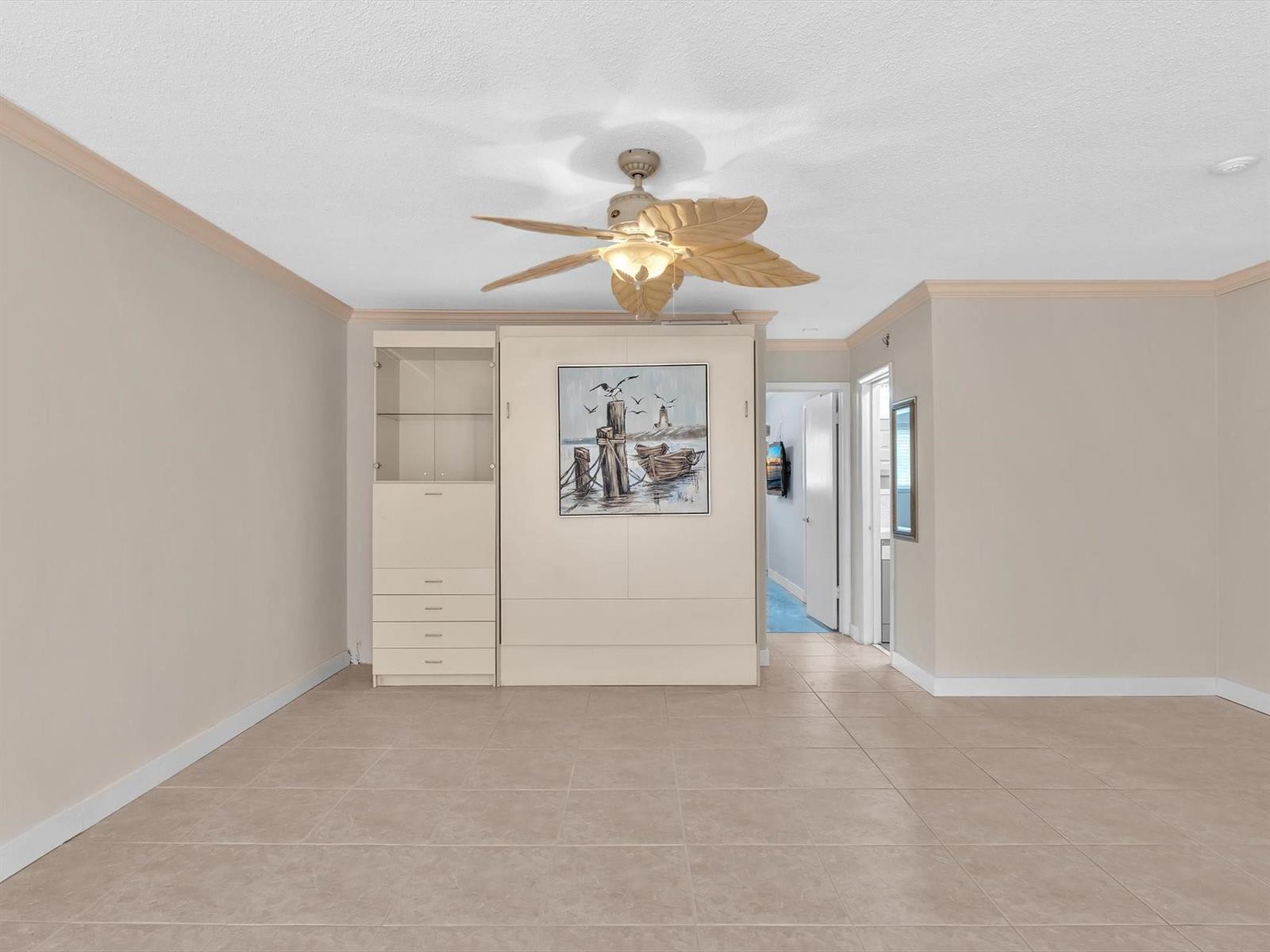 A room with tile flooring, a tropical ceiling fan, and a wall-mounted Murphy bed unit — 2000 Diana Drive # 207, Hallandale Beach FL 33009, HALLANDALE BEACH, FL