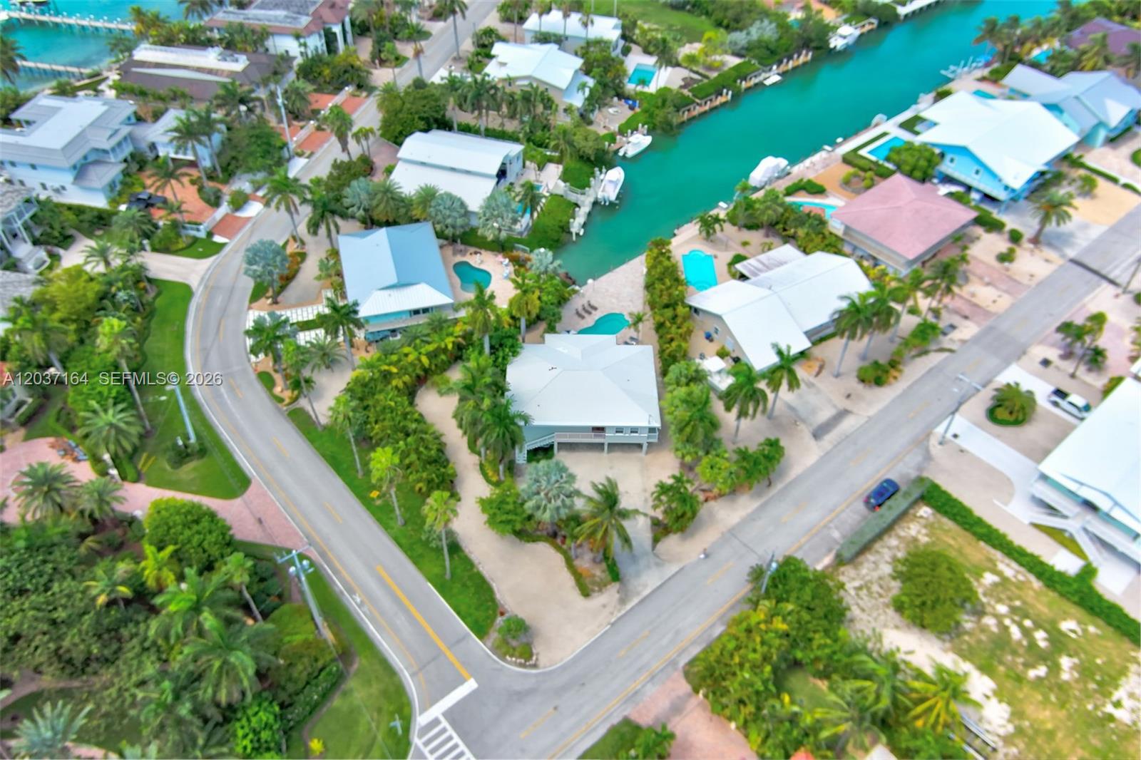 An aerial view shows several houses with pools and boat docks along a canal — 181 12th St, Key Colony FL 33051, KEY COLONY, FL