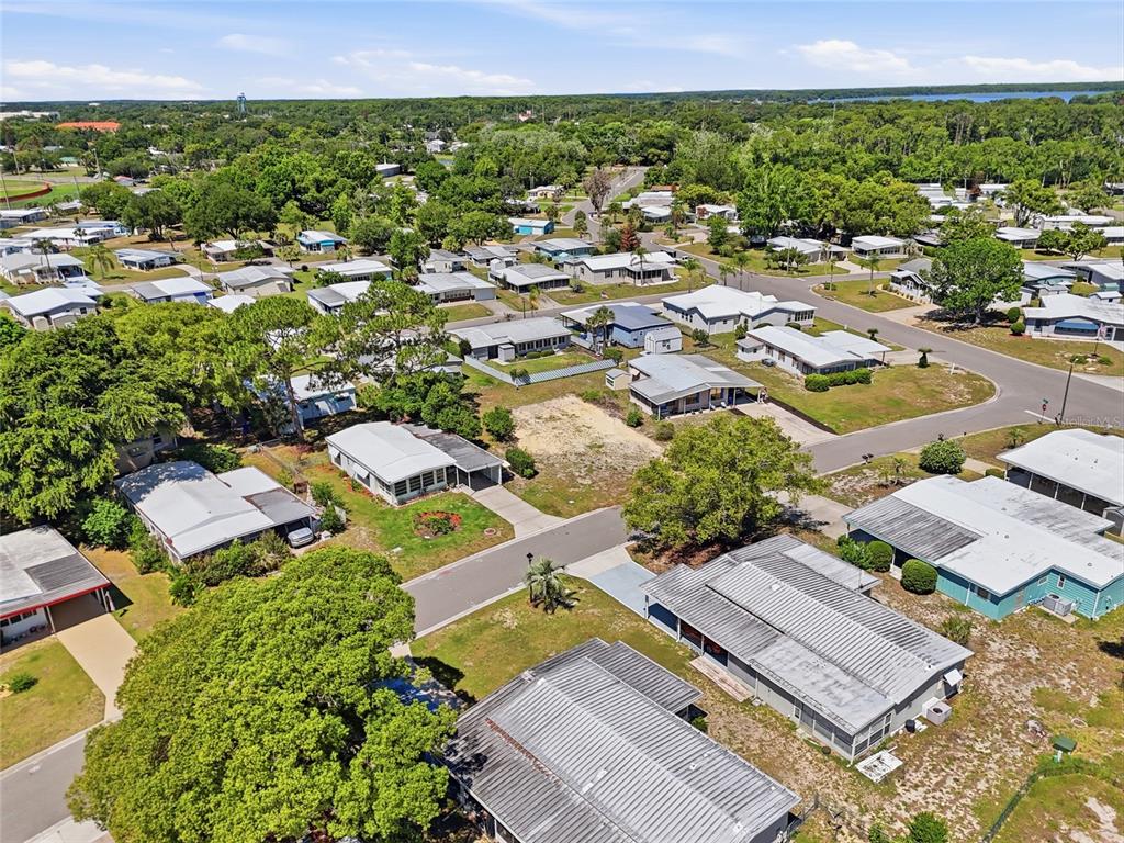 An aerial view shows a residential neighborhood with numerous single-story homes and mature trees — 1223 NASSAU CIRCLE, TAVARES, FL