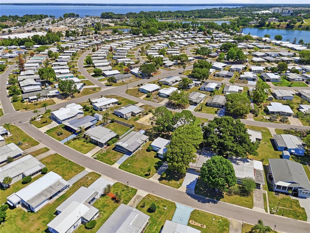Aerial view of a residential mobile home community with paved streets and surrounding water — 1223 NASSAU CIRCLE, TAVARES, FL