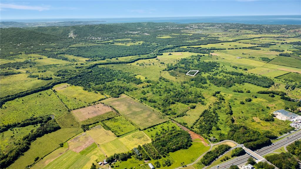 An aerial view shows a large, green rural landscape with a highlighted plot of land — 114 BENAVENTE ROAD UNIT 715, HORMIGUEROS, PR