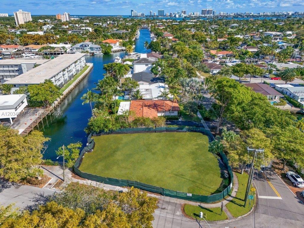 An aerial view shows a vacant, fenced-in waterfront lot next to a residential house — 1805 Ixora Rd, North Miami FL 33181, NORTH MIAMI, FL