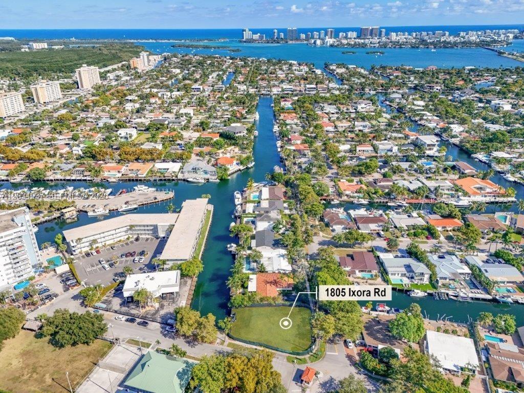 An aerial view shows a vacant waterfront lot situated between a canal and a road — 1805 Ixora Rd, North Miami FL 33181, NORTH MIAMI, FL
