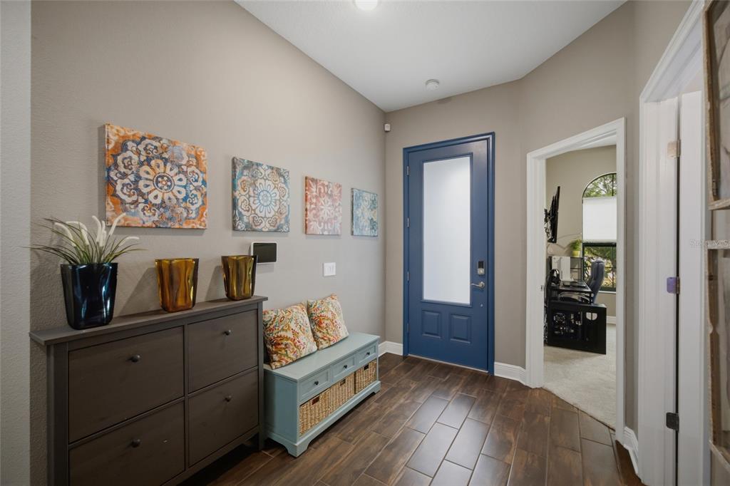 An entryway features a blue front door, a dark wood shoe cabinet, and a storage bench — 2516 W CURTIS STREET, TAMPA, FL