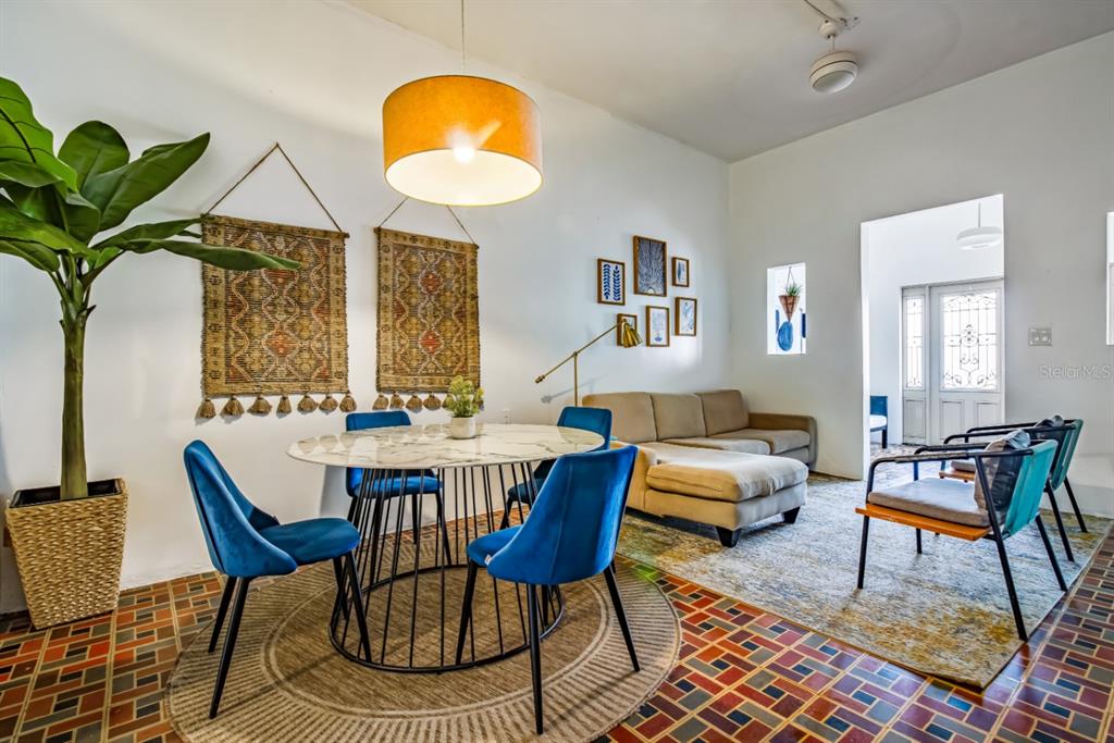 A dining area with blue velvet chairs and a marble table sits beside a living room — 1 PLACID COURT UNIT 71, SAN JUAN, PR