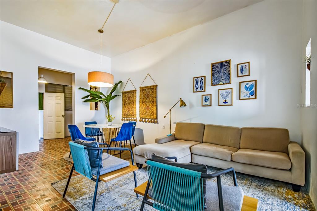 A living and dining area features a beige sectional sofa, blue chairs, and wall art — 1 PLACID COURT UNIT 71, SAN JUAN, PR