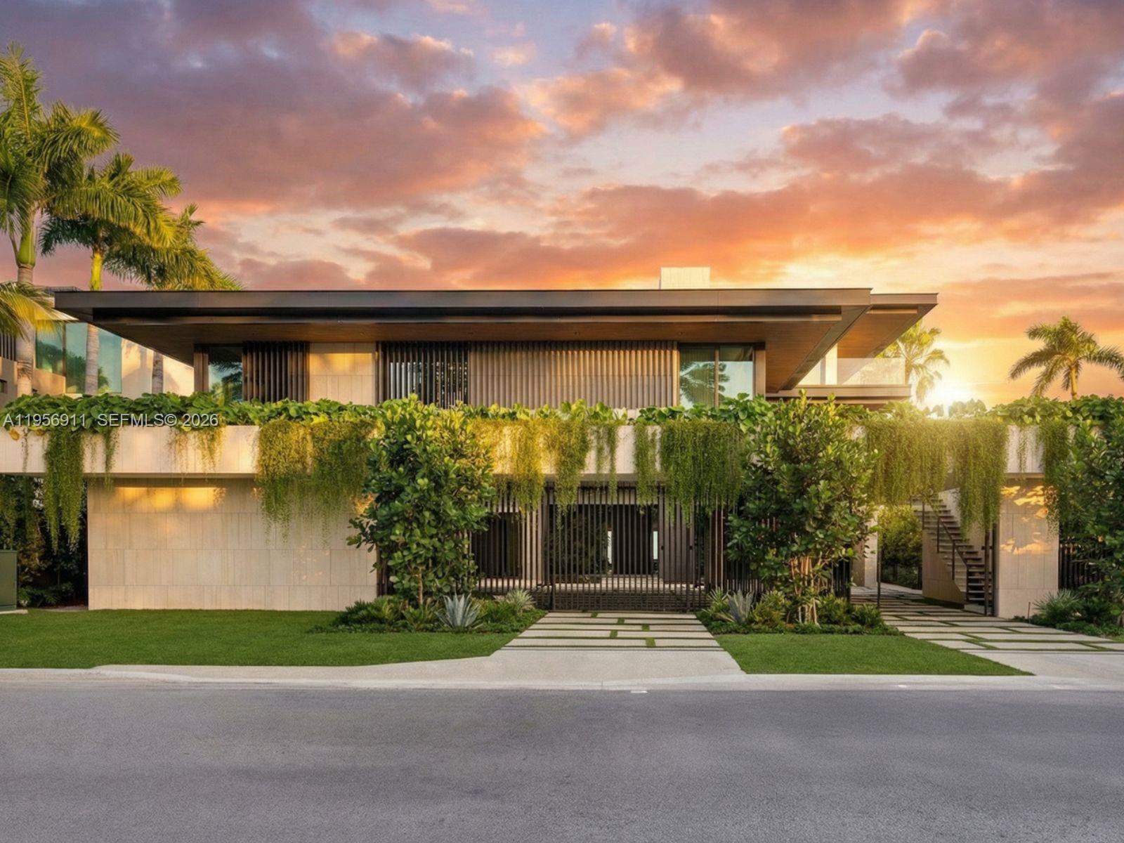 A modern two-story house features stone walls, hanging greenery, and a flat roof at sunset — 255 Ocean Blvd, Golden Beach FL 33160, GOLDEN BEACH, FL