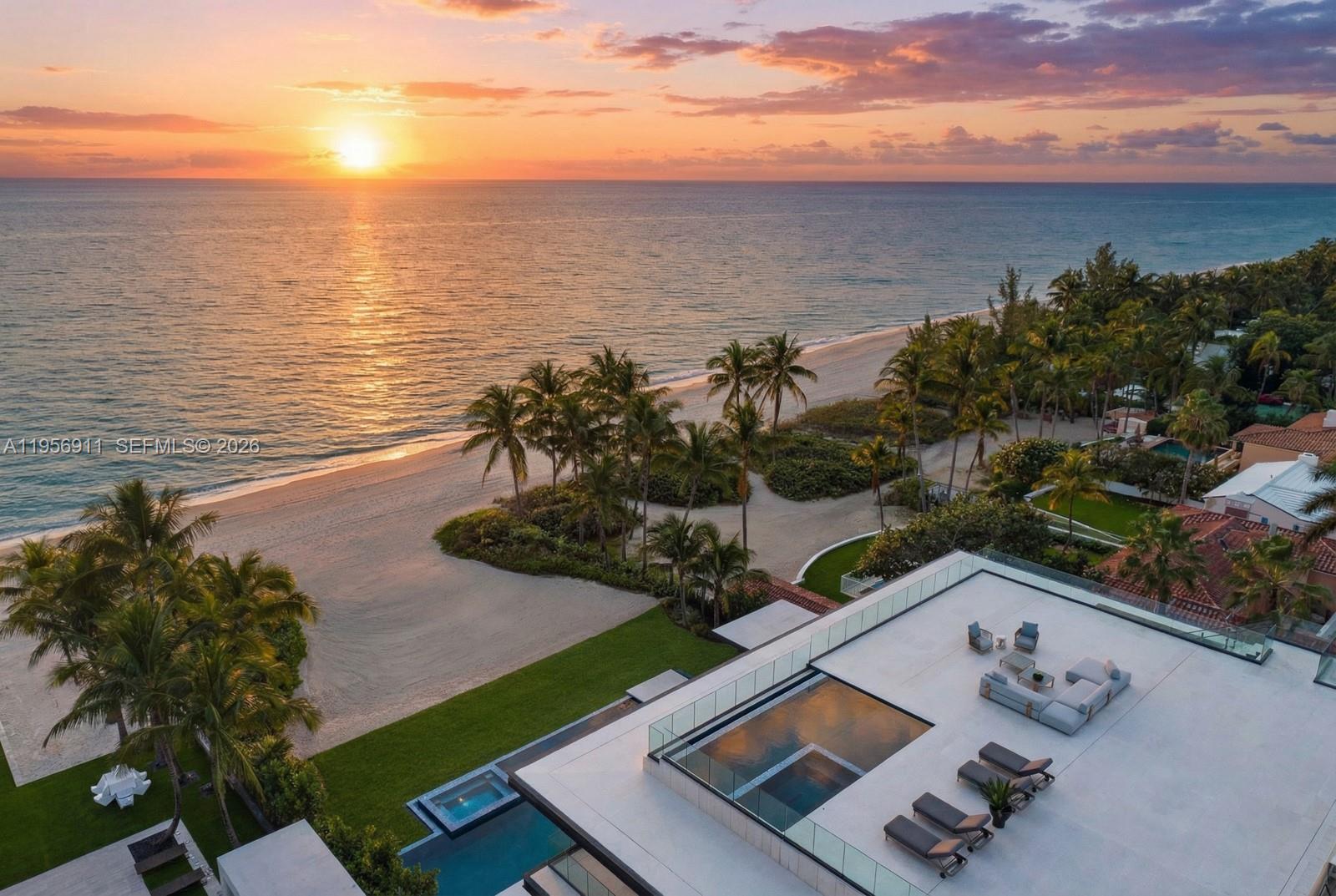 An aerial view shows a modern rooftop terrace with a pool overlooking a sandy beach — 255 Ocean Blvd, Golden Beach FL 33160, GOLDEN BEACH, FL