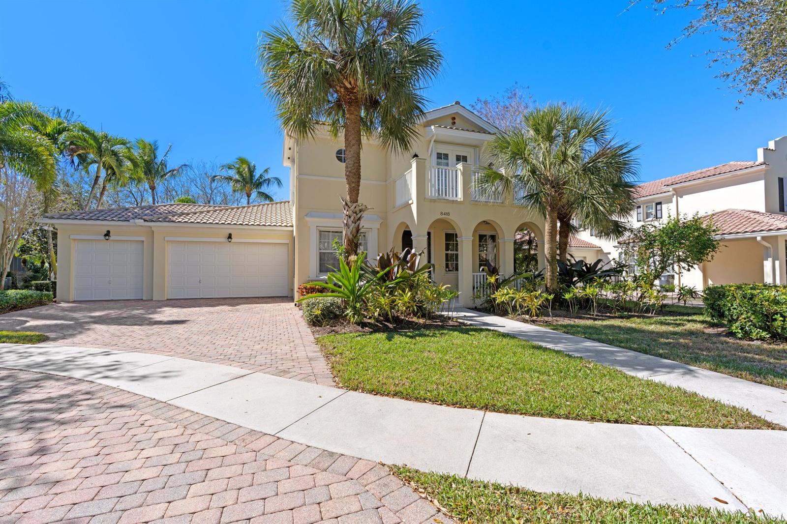 A two-story yellow house with a tile roof, two-car garage, and a front balcony — 8418 Arima Lane, Wellington FL 33414, WELLINGTON, FL