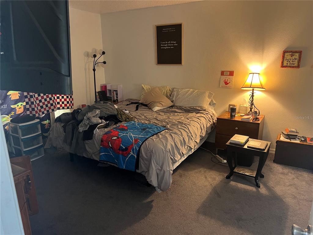 A bedroom features a bed with a Spider-Man blanket, a nightstand, and a floor lamp — 69 RAEMOOR DRIVE, PALM COAST, FL