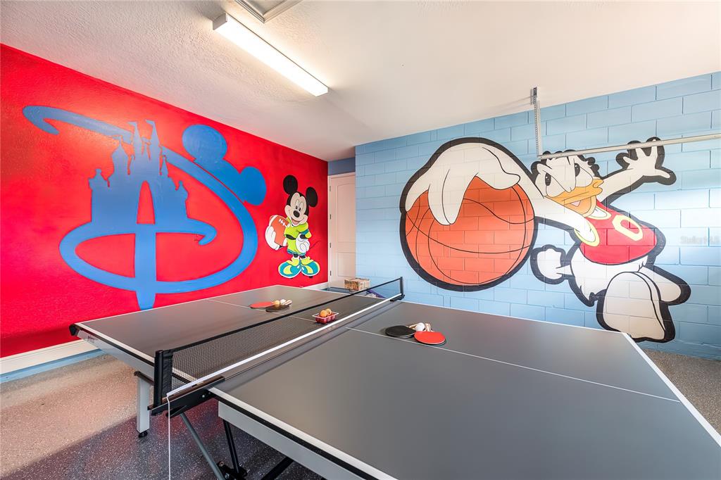 A game room features a ping pong table and walls painted with Disney character murals — 7705 BANYON WAY, KISSIMMEE, FL