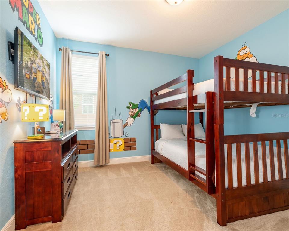 A bedroom features light blue walls, a wooden bunk bed, and Super Mario-themed wall decals — 7705 BANYON WAY, KISSIMMEE, FL