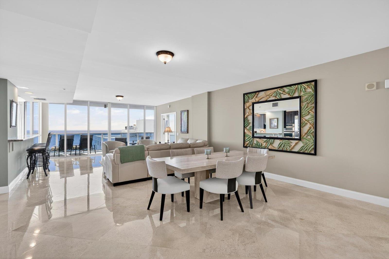 A dining area and living room with tile floors, floor-to-ceiling windows, and ocean views — 801 Briny Avenue # 1501, Pompano Beach FL 33062, POMPANO BEACH, FL