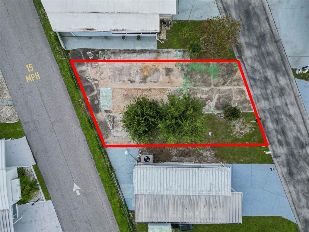 An aerial view shows a rectangular concrete lot outlined in red between two residential structures — 7066 FAIRVIEW VILLAGE CIRCLE, WINTER HAVEN, FL