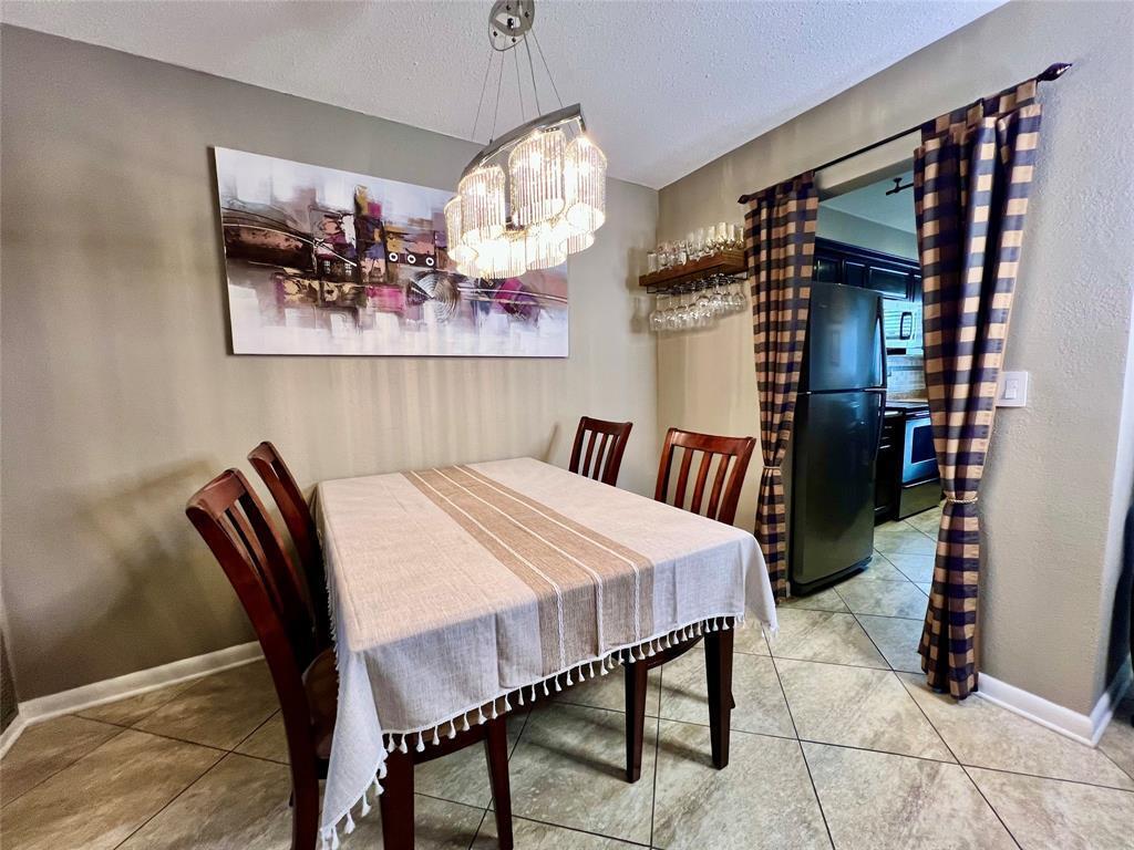 A dining room features a table with a striped cloth, chairs, and a crystal chandelier — 160 NE 8th Avenue # 1b, Hallandale Beach FL 33009, HALLANDALE BEACH, FL