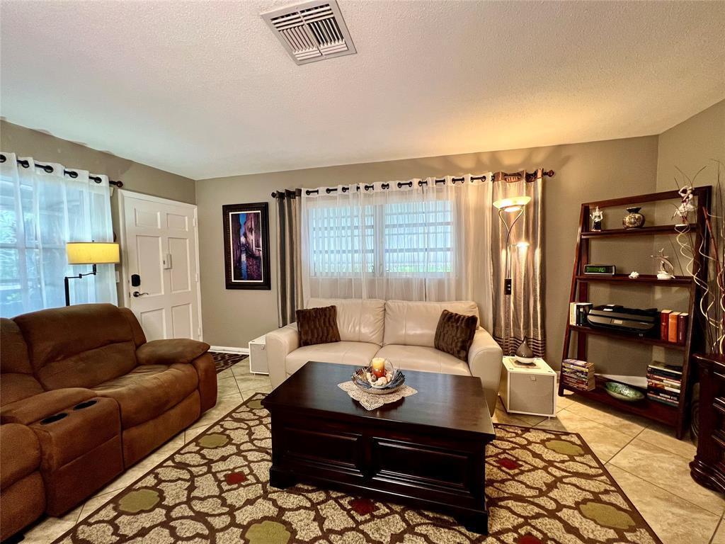 A living room features a brown recliner, a white sofa, a coffee table, and shelving — 160 NE 8th Avenue # 1b, Hallandale Beach FL 33009, HALLANDALE BEACH, FL