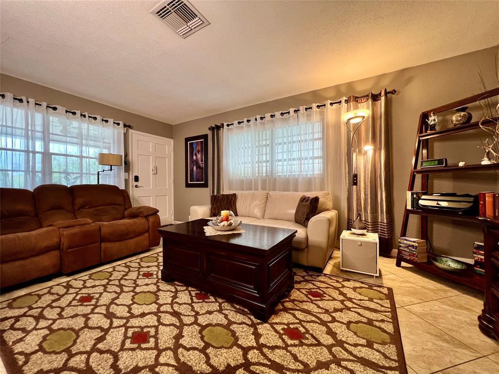 A living room features a brown sofa, a white sofa, a coffee table, and shelving — 160 NE 8th Avenue # 1b, Hallandale Beach FL 33009, HALLANDALE BEACH, FL