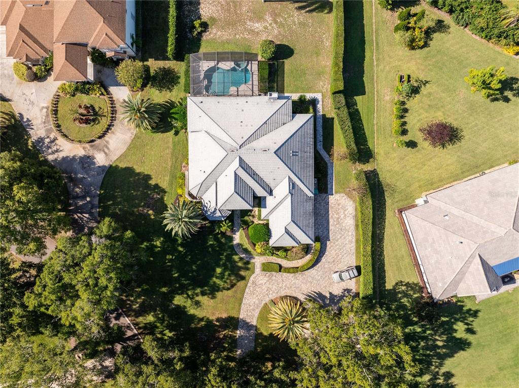 An aerial view shows a house with a pool, screened lanai, and paved driveway — 9002 PINNACLE CIRCLE, WINDERMERE, FL
