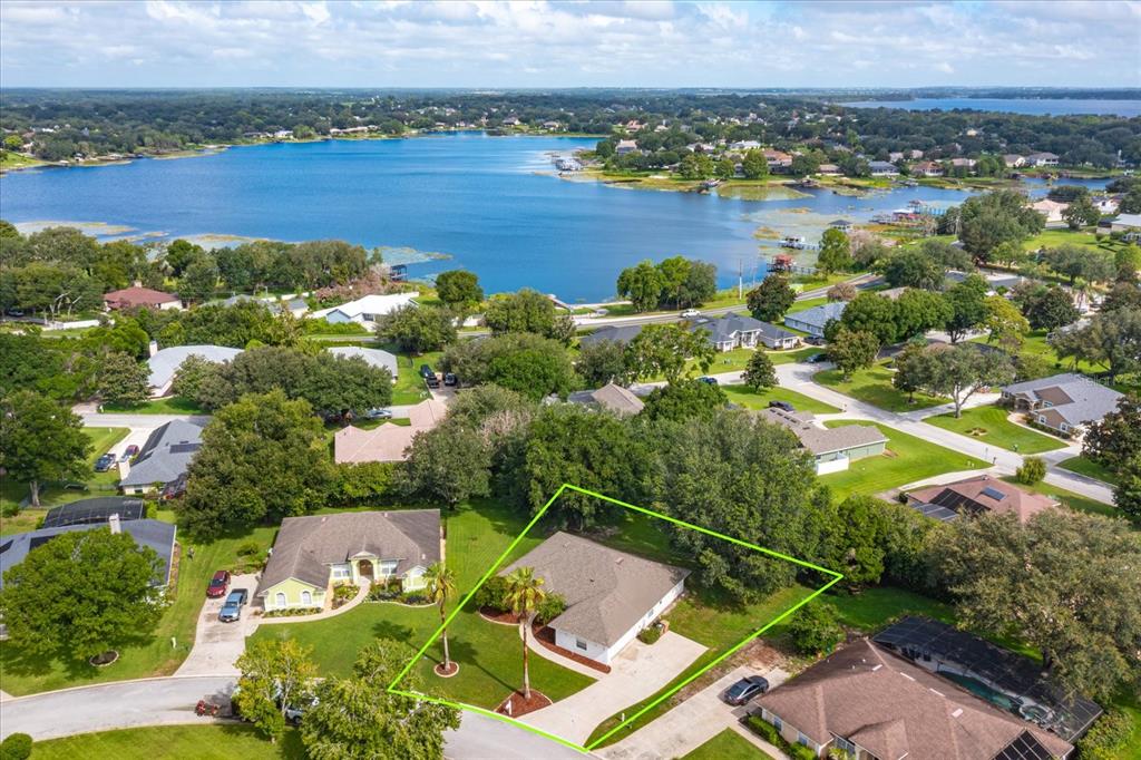 An aerial view of a suburban neighborhood featuring a house highlighted with a green outline — 11316 VIA MARI CAE COURT, CLERMONT, FL