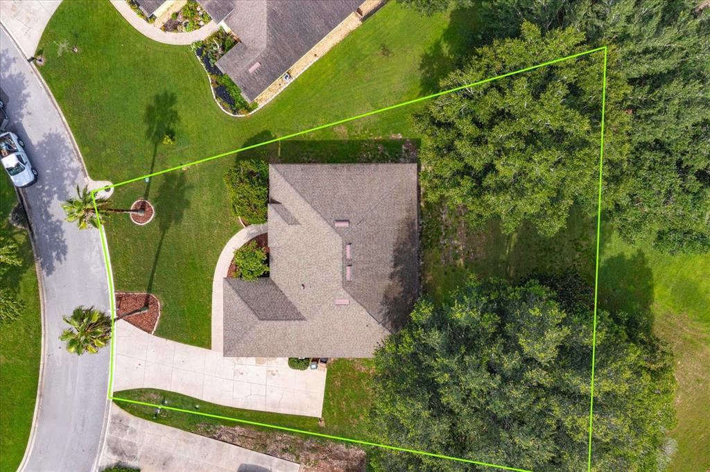 An aerial view shows a house with a concrete driveway situated on a landscaped lot — 11316 VIA MARI CAE COURT, CLERMONT, FL
