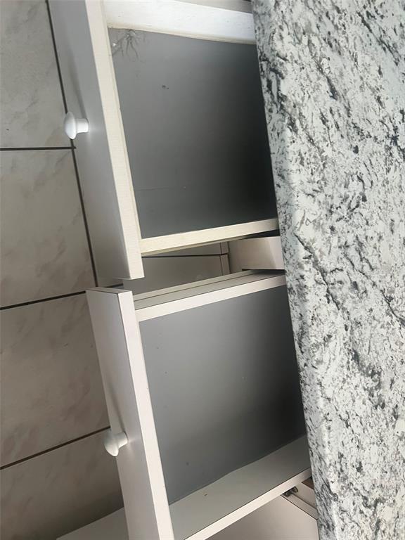 Two open white kitchen drawers are positioned beneath a granite countertop — 5205 DUBLIN PLACE, TAMPA, FL