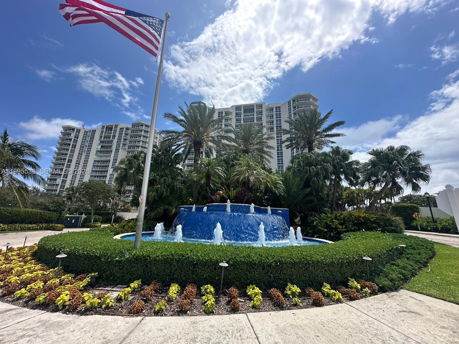 A blue tiered fountain sits in front of palm trees and tall residential buildings — 6001 N Ocean Dr # 503, Hollywood FL 33019, HOLLYWOOD, FL