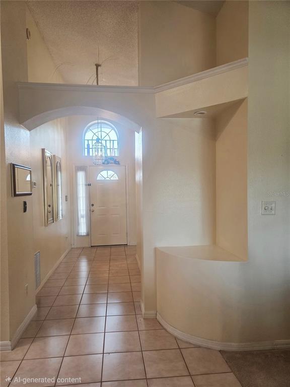A tiled entryway features an arched opening, a built-in display niche, and a front door — 7935 OAKSTONE COURT, ORLANDO, FL