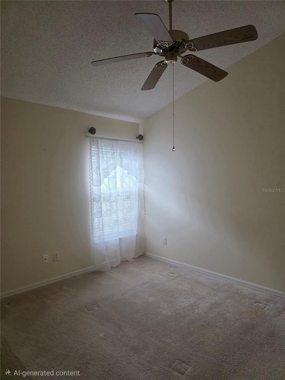An empty bedroom with beige carpet, a ceiling fan, and a window with white curtains — 7935 OAKSTONE COURT, ORLANDO, FL
