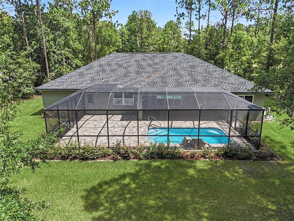 An aerial view of a house with a screened-in pool and patio in a backyard — 20638 SW 88 PLACE ROAD, DUNNELLON, FL