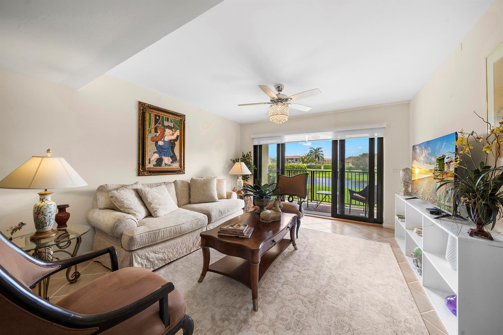 A living room features a beige sofa, wooden coffee table, and sliding doors to a balcony — 601 Seafarer Circle # 104, Jupiter FL 33477, JUPITER, FL