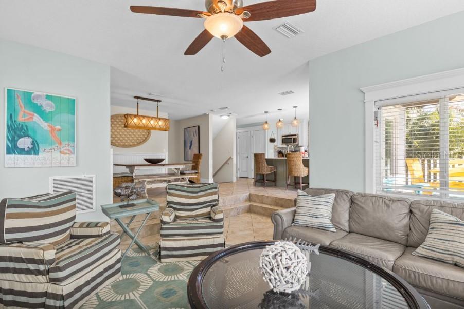 A living room with a sunken seating area, tile floors, and an adjacent dining space — 117 WILLOW AVENUE, ANNA MARIA, FL