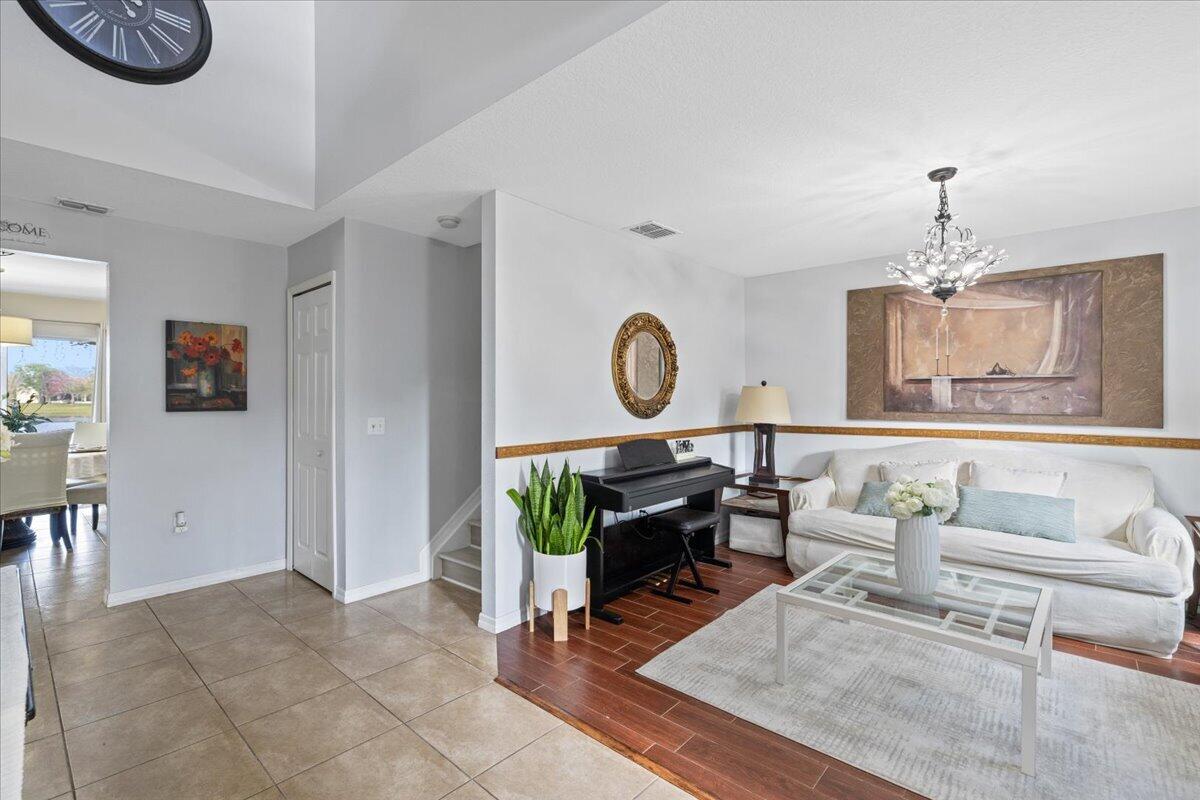 A living room features a white sofa, a glass coffee table, and a piano — 6052 Ridge Lake Circle, Vero Beach FL 32967, VERO BEACH, FL
