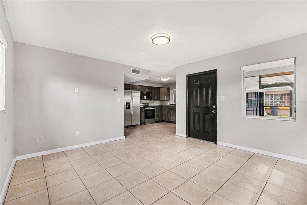 A tiled living area opens into a kitchen with dark cabinets and stainless steel appliances — 514 PALM AVENUE, MERRITT ISLAND, FL