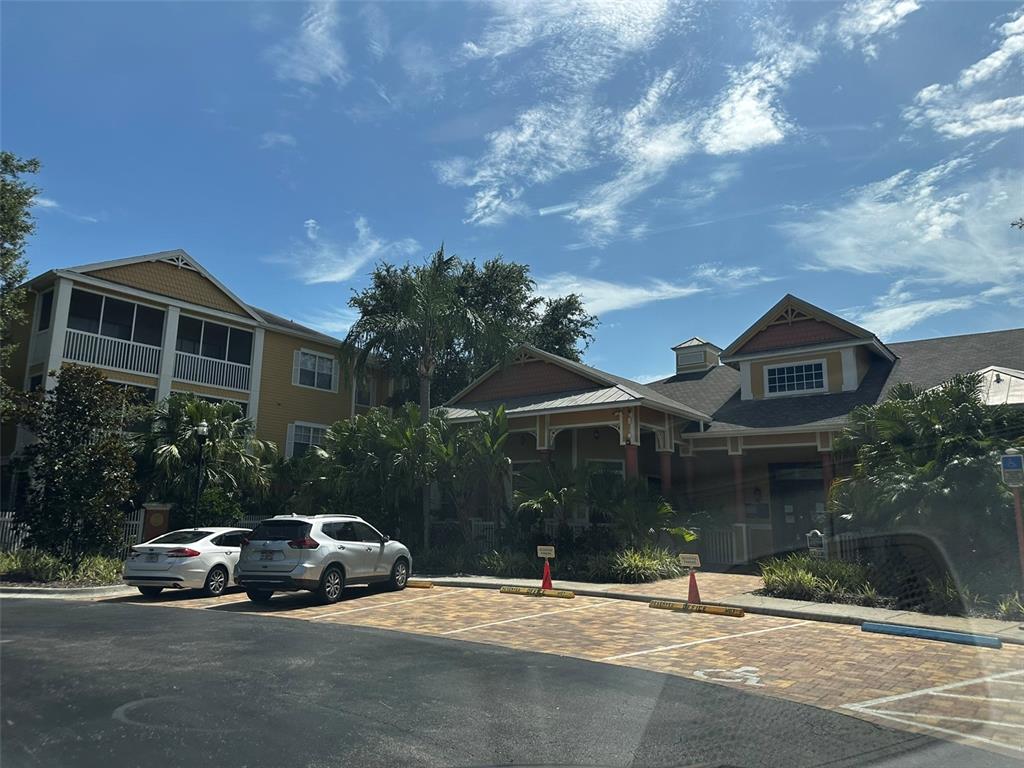A multi-story yellow apartment building with a parking lot and palm trees in front — 4207 S DALE MABRY HIGHWAY UNIT 2103, TAMPA, FL