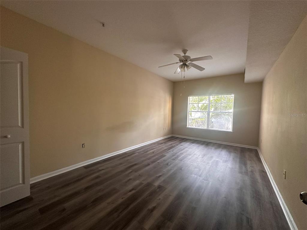 An empty room features light-colored walls, a ceiling fan, and wood-look flooring — 4207 S DALE MABRY HIGHWAY UNIT 2103, TAMPA, FL