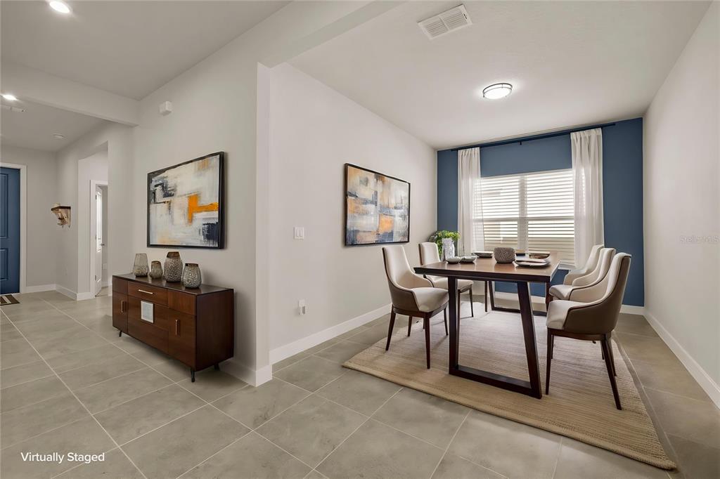 A dining room with a wooden table, chairs, and a blue accent wall — 1714 UPLAND LANE, WINTER HAVEN, FL
