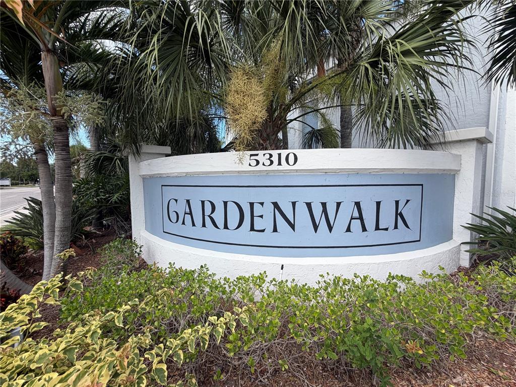 A curved sign for Gardenwalk stands in front of palm trees and landscaping — 5310 26TH STREET W UNIT 2904, BRADENTON, FL