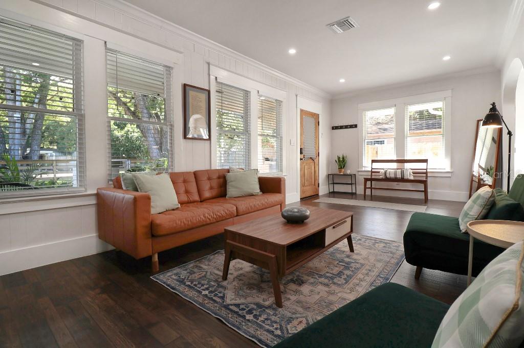 A living room with a brown leather sofa, green chairs, and a wooden coffee table — 9310 N 18TH STREET, TAMPA, FL