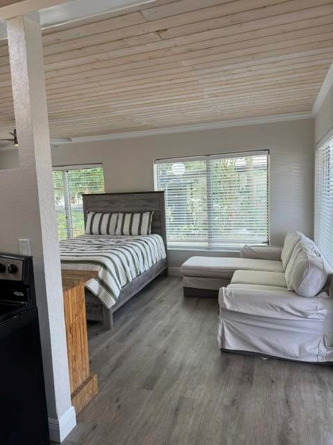 A bedroom with a wooden ceiling, a bed with striped bedding, and a white sofa — 131 S Federal Highway # 3, FL 33460, FL