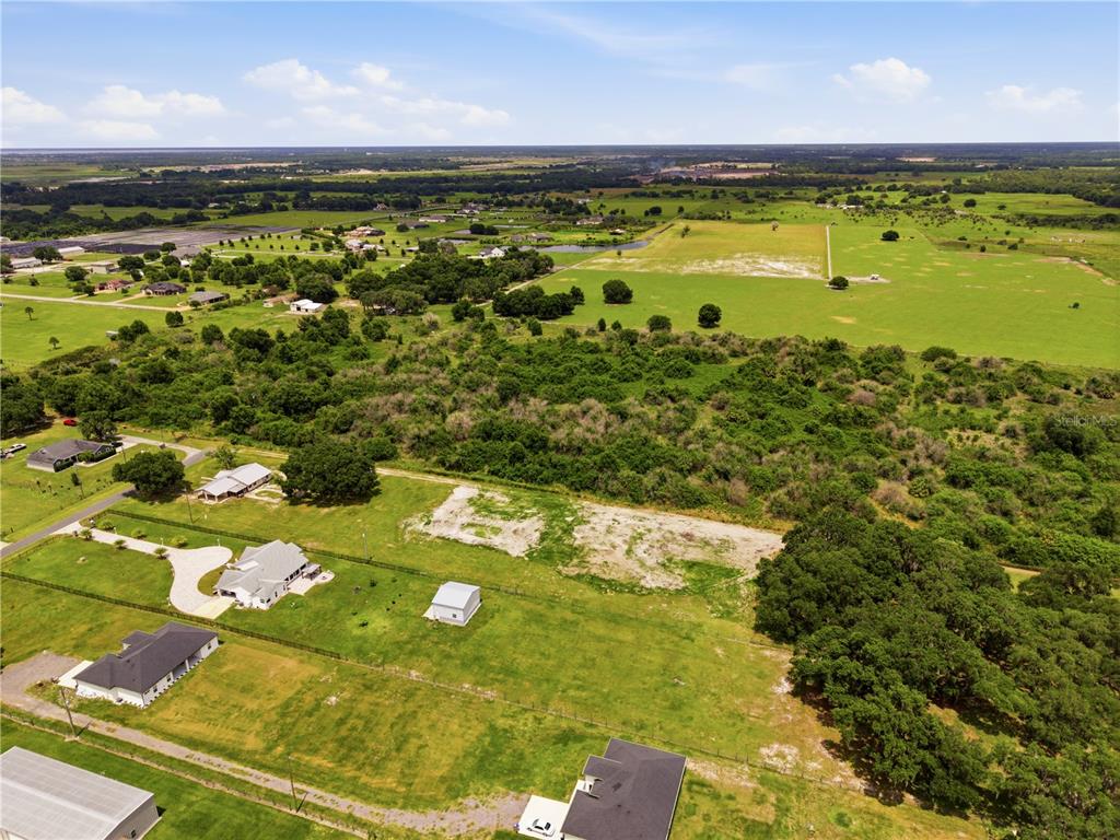 An aerial view shows a rural property with several houses, open fields, and wooded areas — PARKWAY AVENUE, ST CLOUD, FL