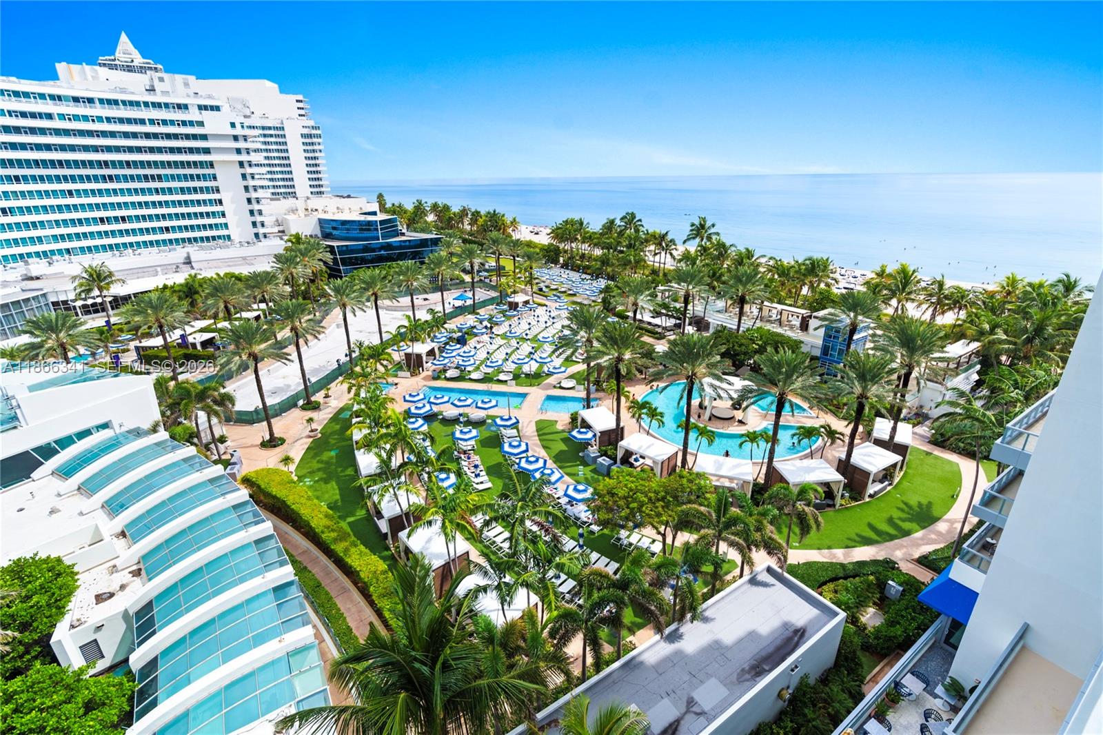 An aerial view shows a resort pool area with palm trees, cabanas, and beach access — 4391 Collins Ave # 803, Miami Beach FL 33140, MIAMI BEACH, FL