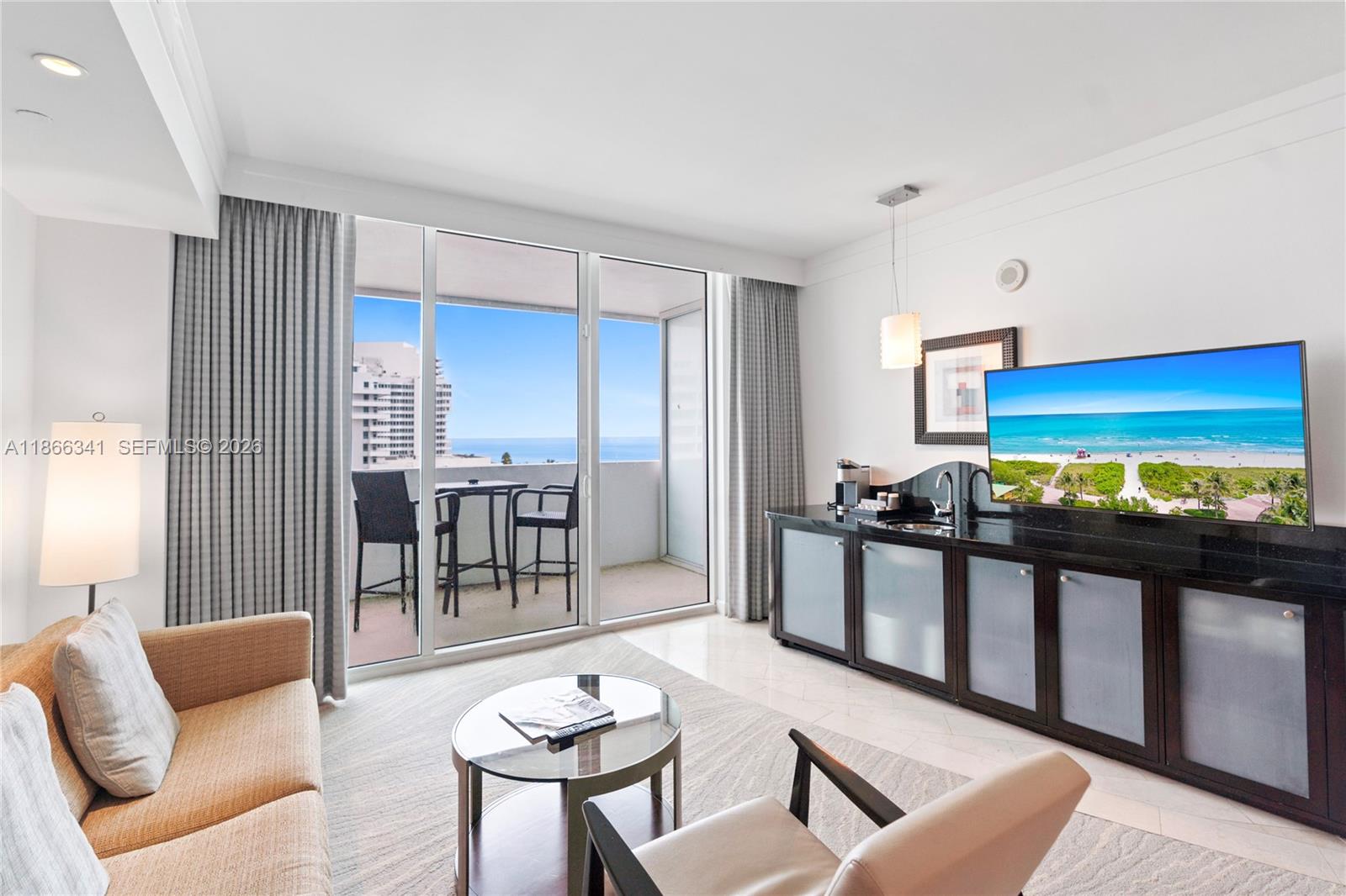A living room features a sofa, glass coffee table, kitchenette, and a balcony with ocean views — 4391 Collins Ave # 803, Miami Beach FL 33140, MIAMI BEACH, FL