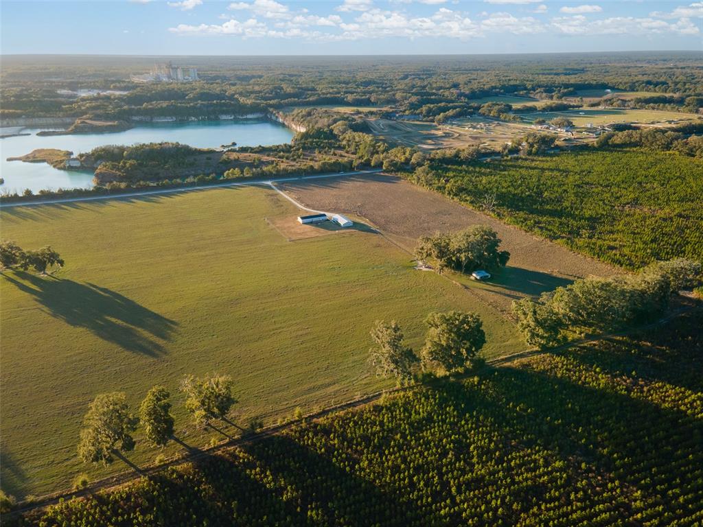 An aerial view shows a large grassy field with a small building and surrounding trees — 3789 NW 202ND STREET, NEWBERRY, FL
