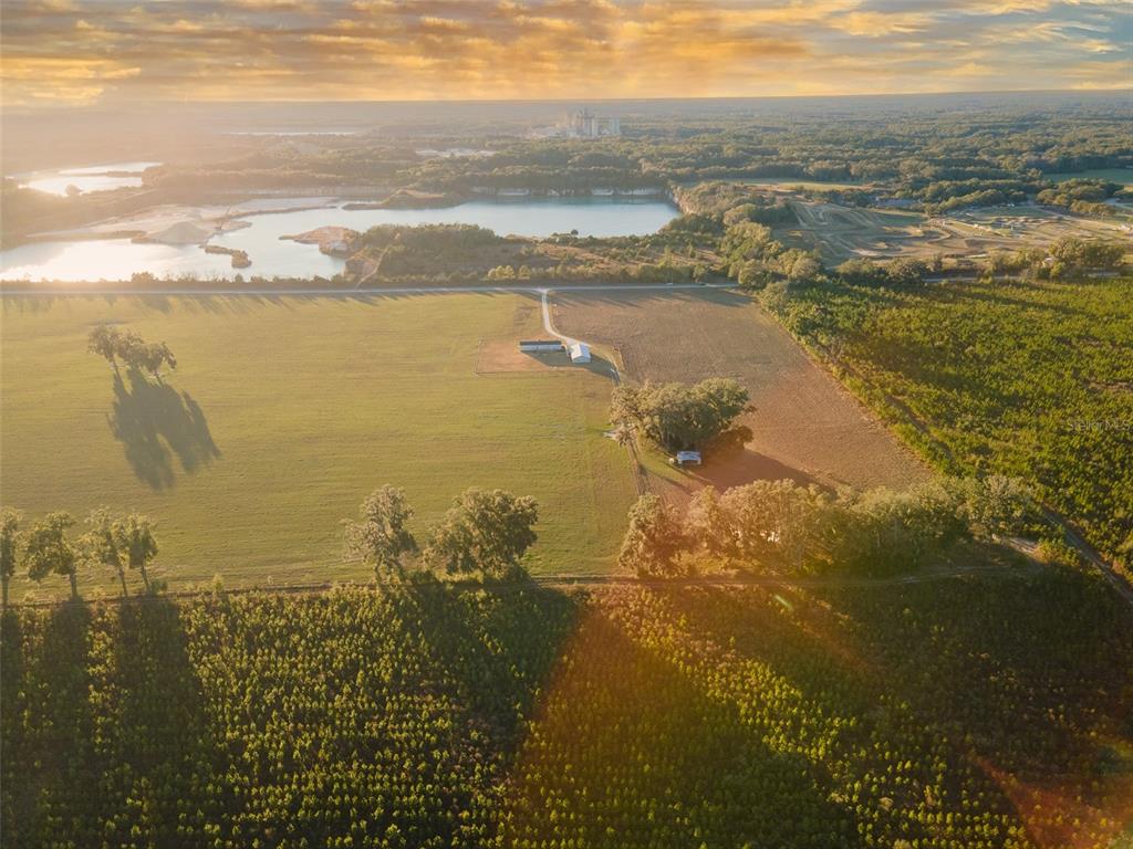 An aerial view shows a rural property with a house, pasture, and nearby lake — 3789 NW 202ND STREET, NEWBERRY, FL