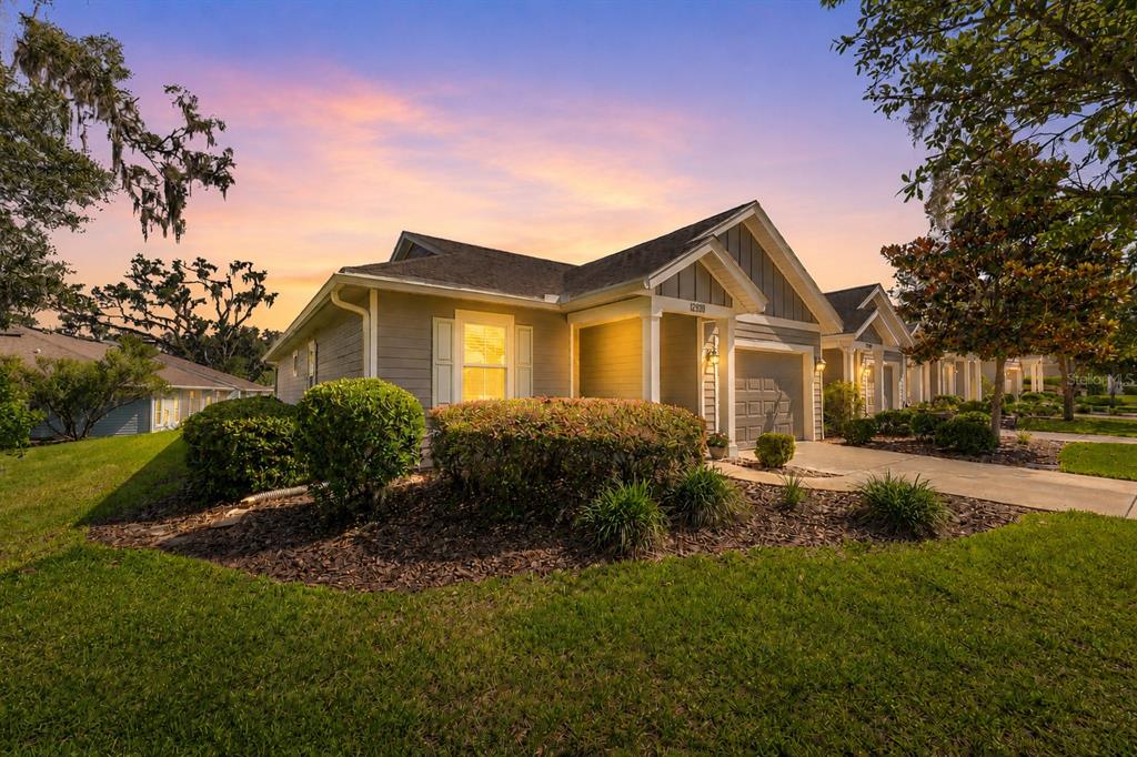A single-story house with gray siding and a garage at sunset — 12938 NW 11TH PLACE, NEWBERRY, FL