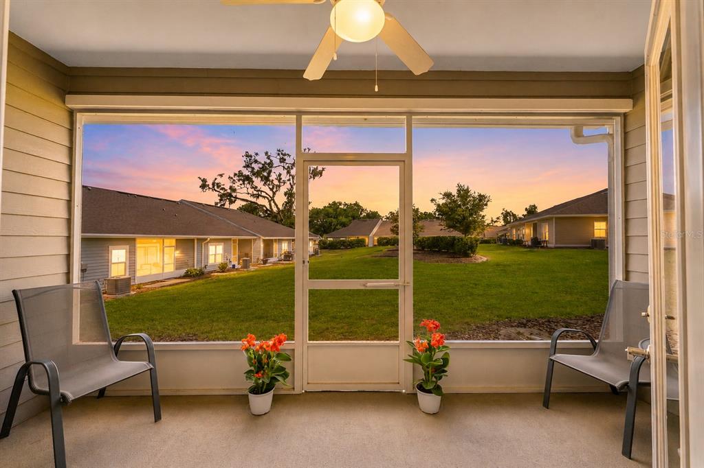 A screened-in porch features two chairs, potted flowers, and a view of a grassy lawn — 12938 NW 11TH PLACE, NEWBERRY, FL