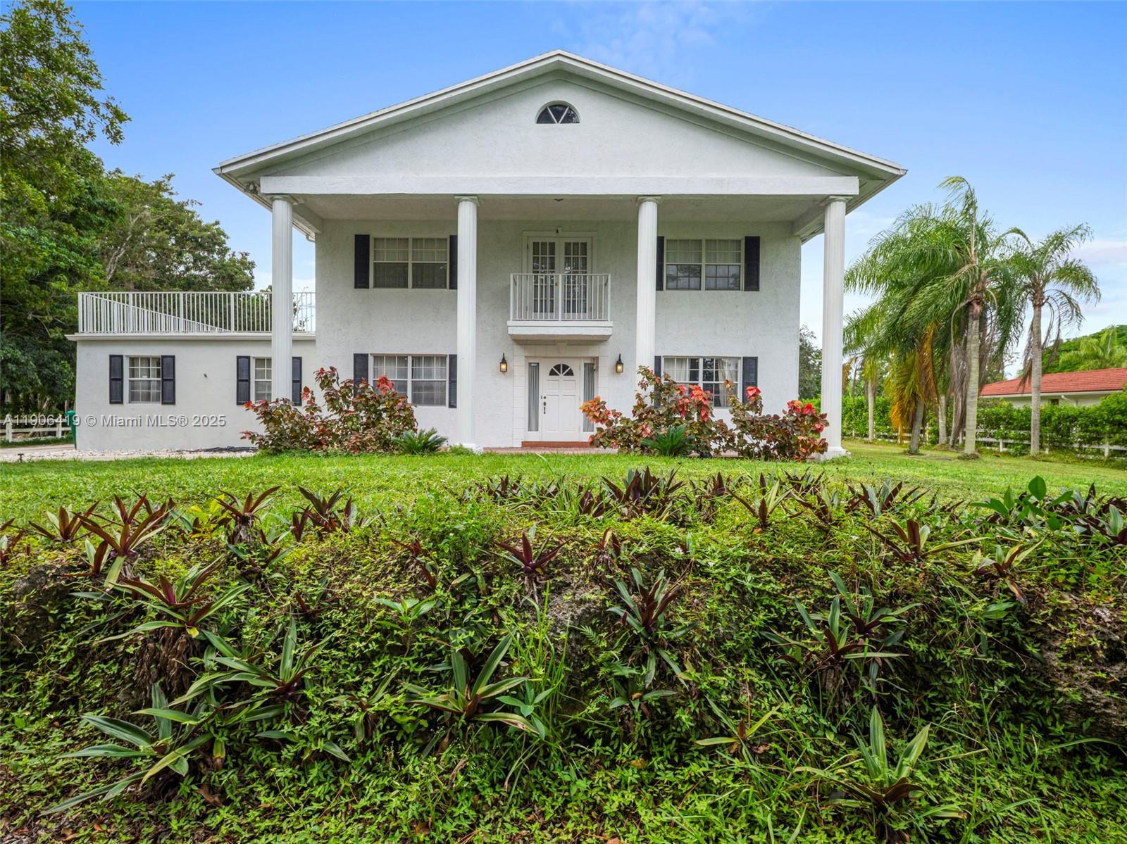 A two-story white house with a columned porch and a second-floor balcony — 6365 NW 79th Way, Parkland FL 33067, PARKLAND, FL